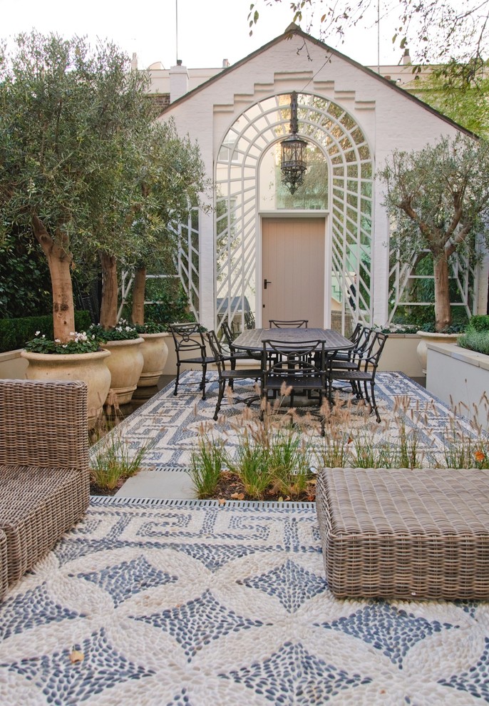 Inspiration for a mid-sized mediterranean backyard patio in Hertfordshire with no cover and a container garden.