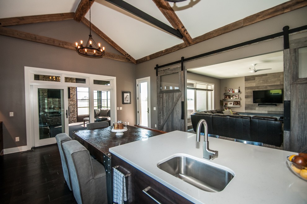 Large mountain style dark wood floor and brown floor eat-in kitchen photo with an undermount sink, flat-panel cabinets, medium tone wood cabinets, quartz countertops, green backsplash, glass sheet backsplash, stainless steel appliances and an island