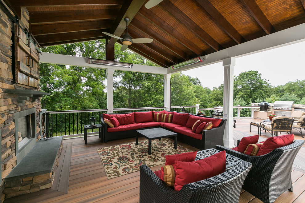 Inspiration for a large traditional backyard deck in Baltimore with a fire feature and a roof extension.