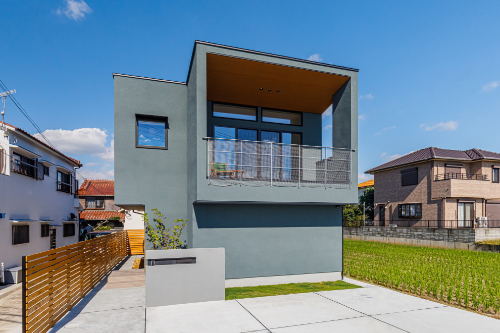 Mittelgroßes, Zweistöckiges Asiatisches Einfamilienhaus mit grauer Fassadenfarbe, Flachdach, Blechdach und grauem Dach in Sonstige