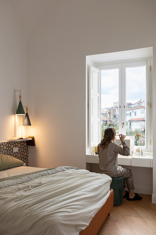 Réalisation d'une chambre parentale nordique avec un mur blanc et parquet clair.