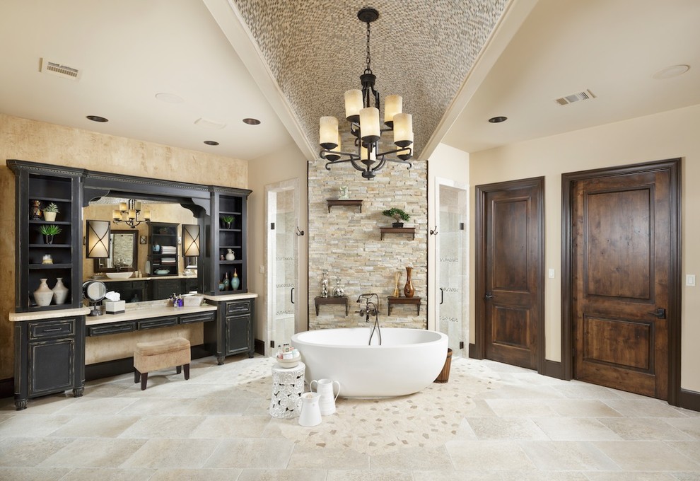 Large mediterranean master bathroom in Houston with black cabinets, a freestanding tub, beige tile, porcelain tile, beige walls, porcelain floors, a corner shower, recessed-panel cabinets and beige floor.