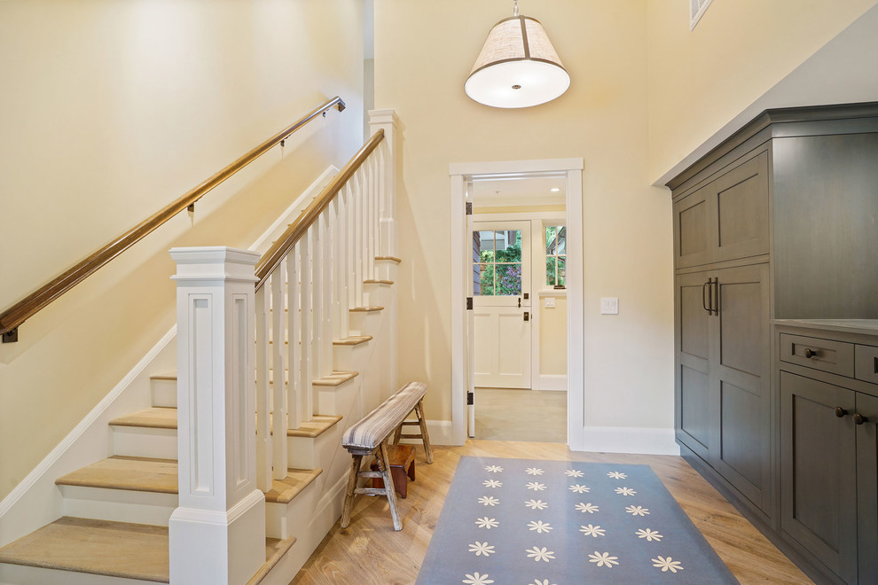 Large country hallway in San Francisco with yellow walls and light hardwood floors.