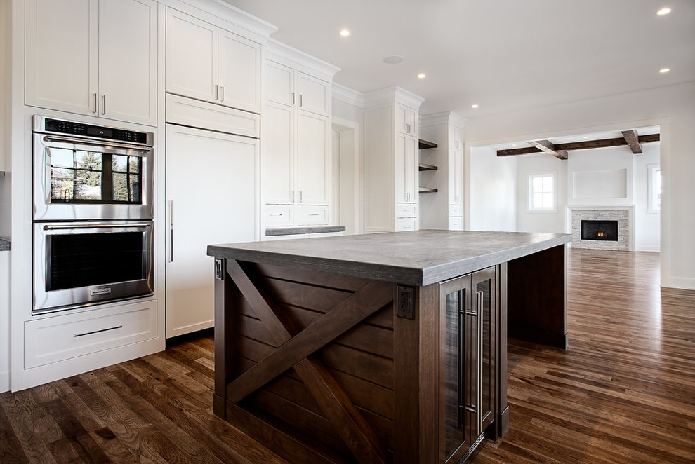 Inspiration for a large transitional u-shaped eat-in kitchen remodel in Calgary with shaker cabinets, paneled appliances and an island