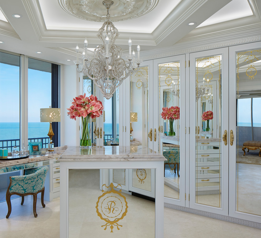 Inspiration for a traditional dressing room in Miami with recessed-panel cabinets, white cabinets and beige floor.