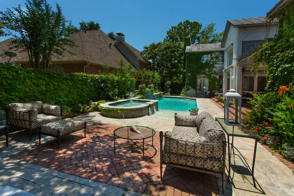 Photo of a mid-sized traditional backyard rectangular lap pool in Dallas with a water feature and natural stone pavers.