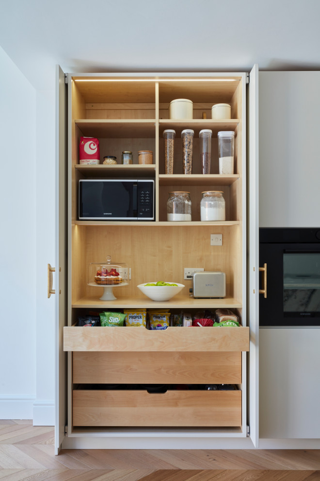 Design ideas for a medium sized modern kitchen in London with flat-panel cabinets and an island.