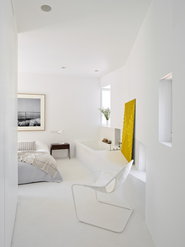 This is an example of a modern master bedroom in Madrid with white walls.