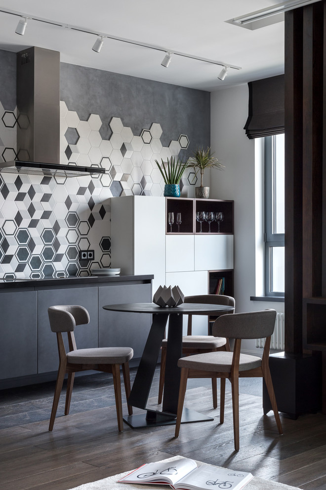 Inspiration for a mid-sized contemporary single-wall open plan kitchen in Moscow with a single-bowl sink, flat-panel cabinets, black cabinets, solid surface benchtops, multi-coloured splashback, porcelain splashback, black appliances, porcelain floors, no island, black floor and black benchtop.
