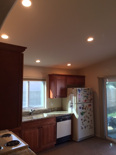 Inspiration for a small transitional l-shaped ceramic tile eat-in kitchen remodel in Phoenix with an undermount sink, raised-panel cabinets, medium tone wood cabinets, granite countertops, white appliances and no island