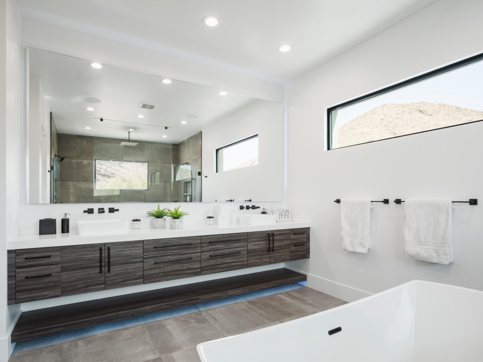 Inspiration for a large modern master bathroom in Phoenix with flat-panel cabinets, grey cabinets, a freestanding tub, an open shower, a one-piece toilet, white tile, marble, white walls, porcelain floors, a vessel sink, engineered quartz benchtops, grey floor, an open shower, white benchtops, a shower seat, a double vanity, a floating vanity and decorative wall panelling.
