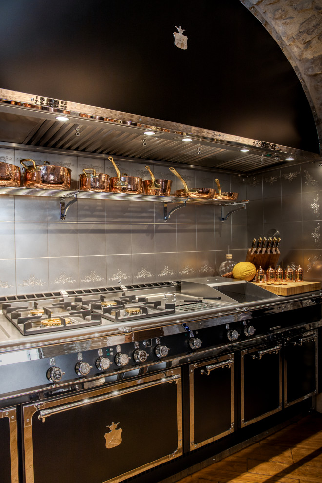 Foto di una grande cucina ad U eclettica chiusa con lavello integrato e top in acciaio inossidabile