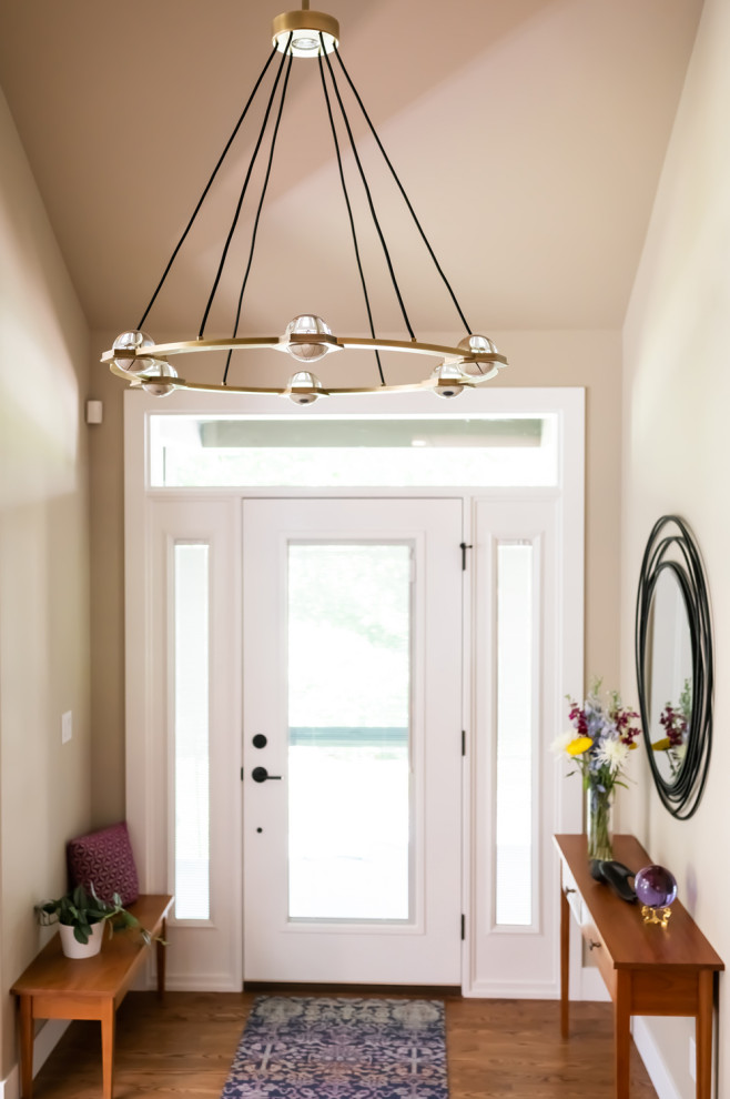 Ejemplo de puerta principal abovedada minimalista de tamaño medio con paredes beige, suelo de madera en tonos medios, puerta simple, puerta de vidrio y suelo marrón