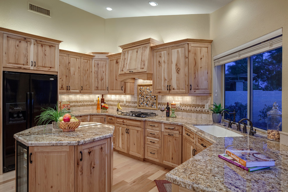 Enclosed kitchen - large rustic u-shaped light wood floor enclosed kitchen idea in Phoenix with an undermount sink, raised-panel cabinets, light wood cabinets, granite countertops, beige backsplash, ceramic backsplash, black appliances and an island