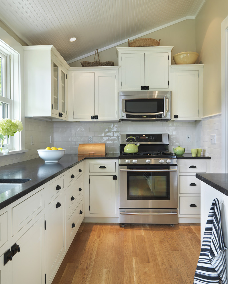 Photo of a traditional kitchen in Providence with shaker cabinets, white cabinets, white splashback, subway tile splashback and stainless steel appliances.