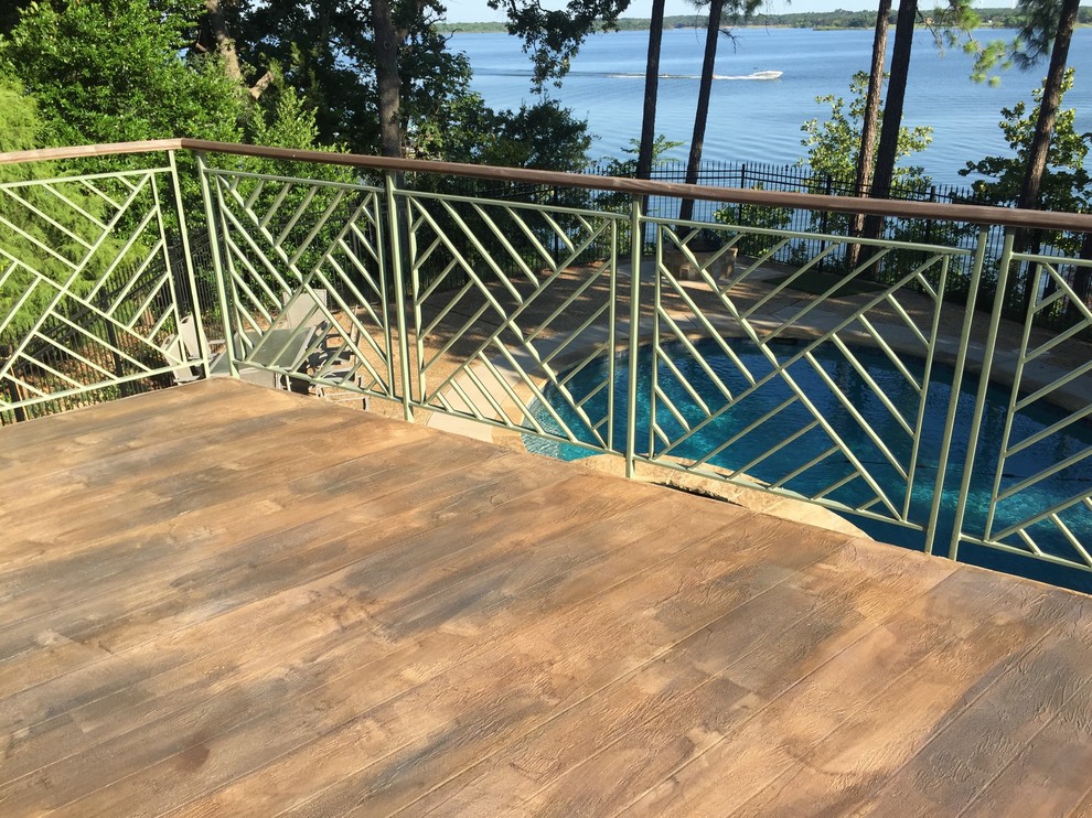 This is an example of a large country backyard deck in Dallas with a roof extension.