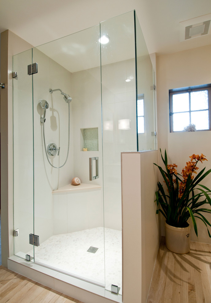 Mid-sized bathroom in Albuquerque with a corner shower, light hardwood floors, beige walls, beige floor, a hinged shower door, flat-panel cabinets, white cabinets and an undermount sink.