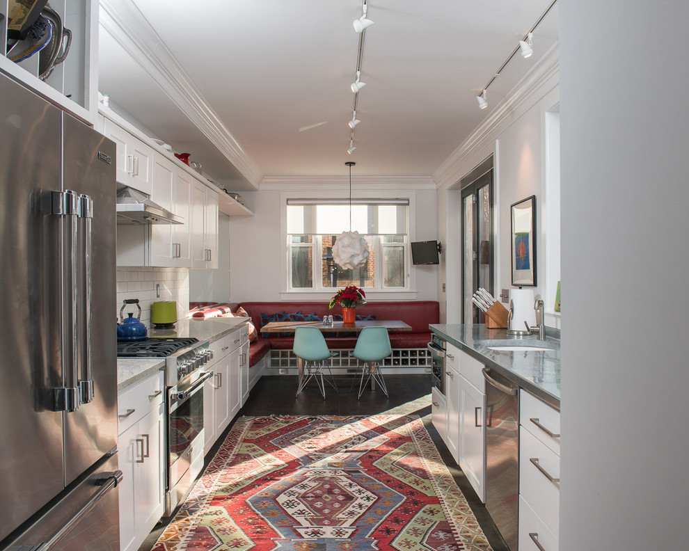 Design ideas for a contemporary galley eat-in kitchen in DC Metro with an undermount sink, shaker cabinets, white cabinets, white splashback, subway tile splashback and stainless steel appliances.