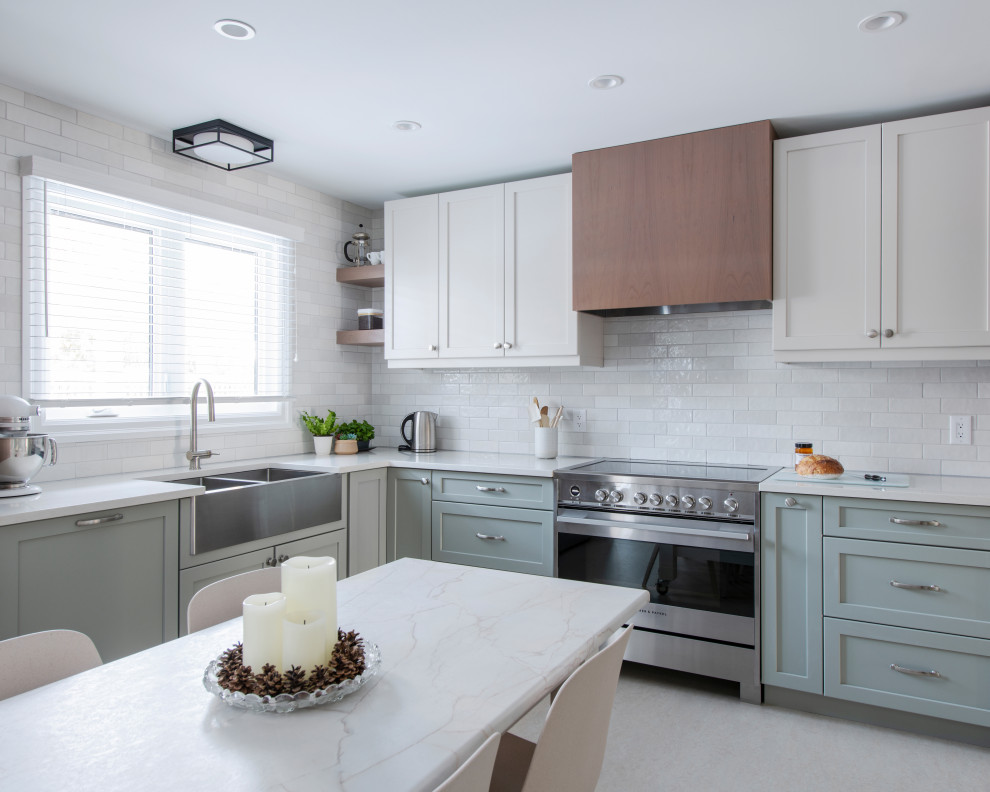 Inspiration for a mid-sized transitional u-shaped linoleum floor and gray floor eat-in kitchen remodel in Ottawa with a farmhouse sink, shaker cabinets, gray cabinets, quartz countertops, white backsplash, subway tile backsplash, stainless steel appliances, an island and white countertops