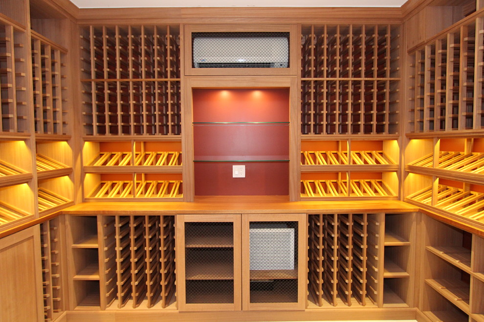 Inspiration for a mid-sized traditional wine cellar in New York with display racks, light hardwood floors and beige floor.