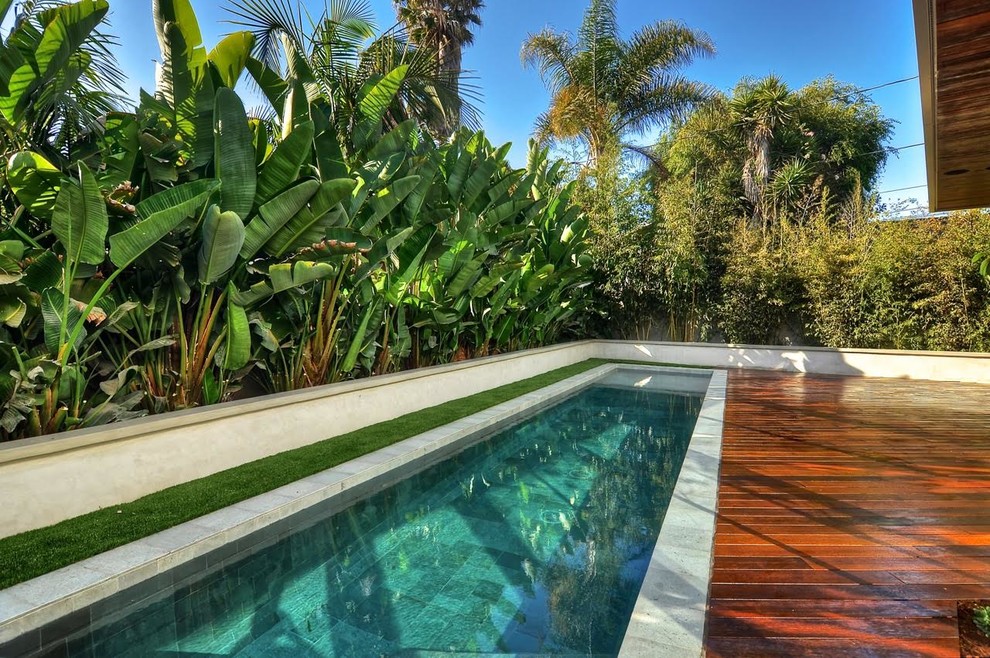 This is an example of a large contemporary side yard rectangular lap pool in Orange County with decking.