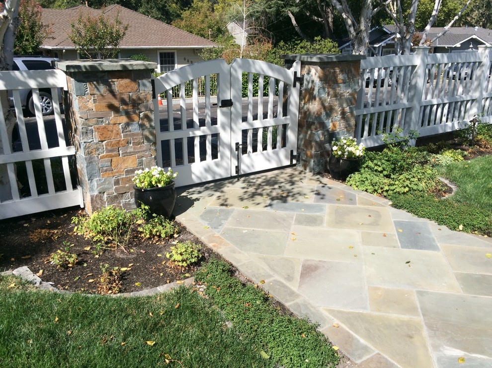 Large traditional front yard full sun garden in Other with natural stone pavers for summer.