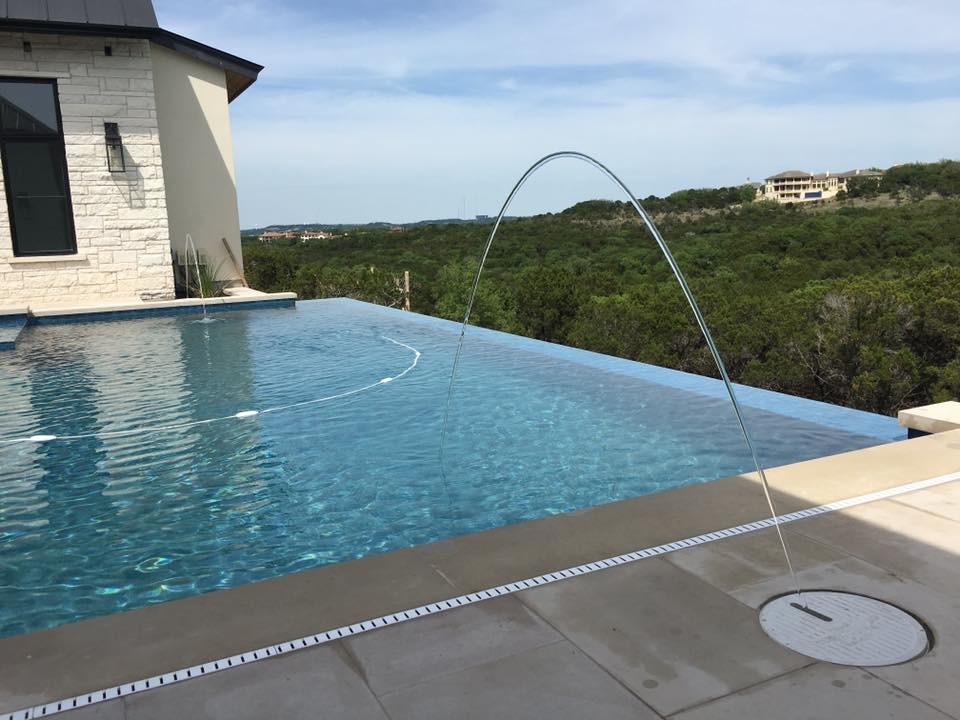 Inspiration for a large modern backyard concrete and rectangular infinity hot tub remodel in Austin