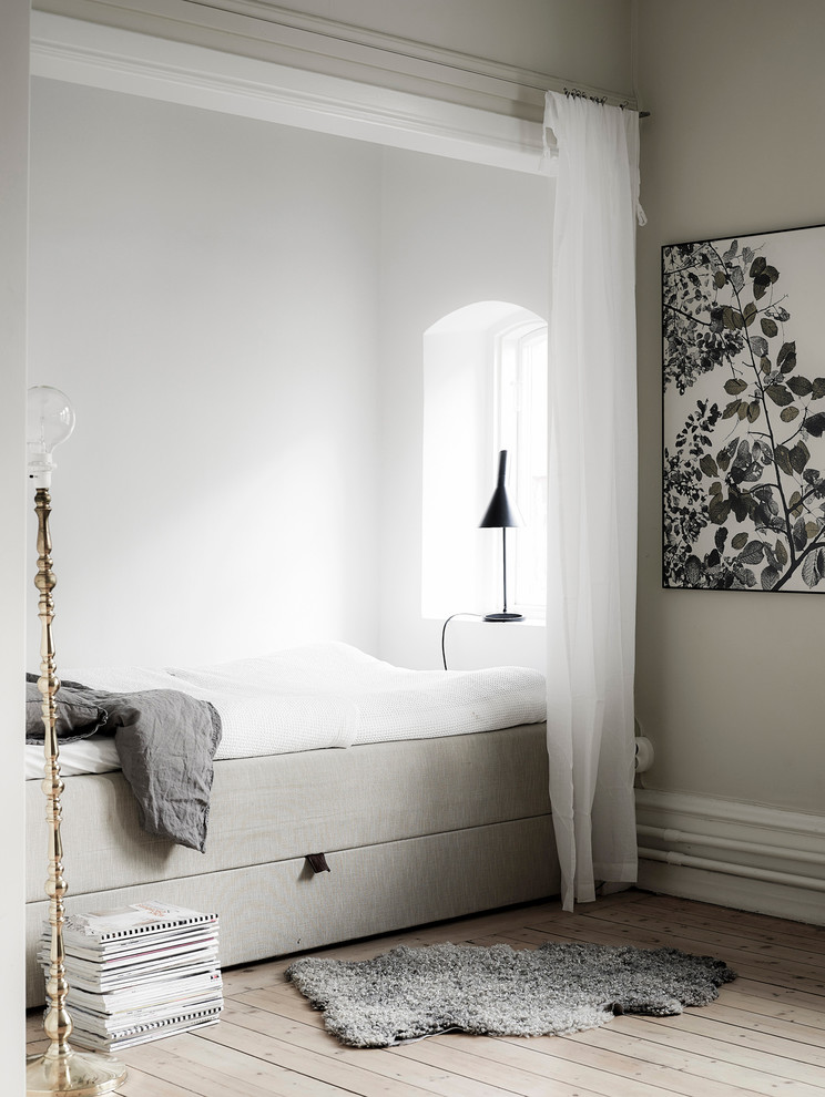 Photo of a small scandinavian guest bedroom in Gothenburg with light hardwood floors, beige walls and no fireplace.