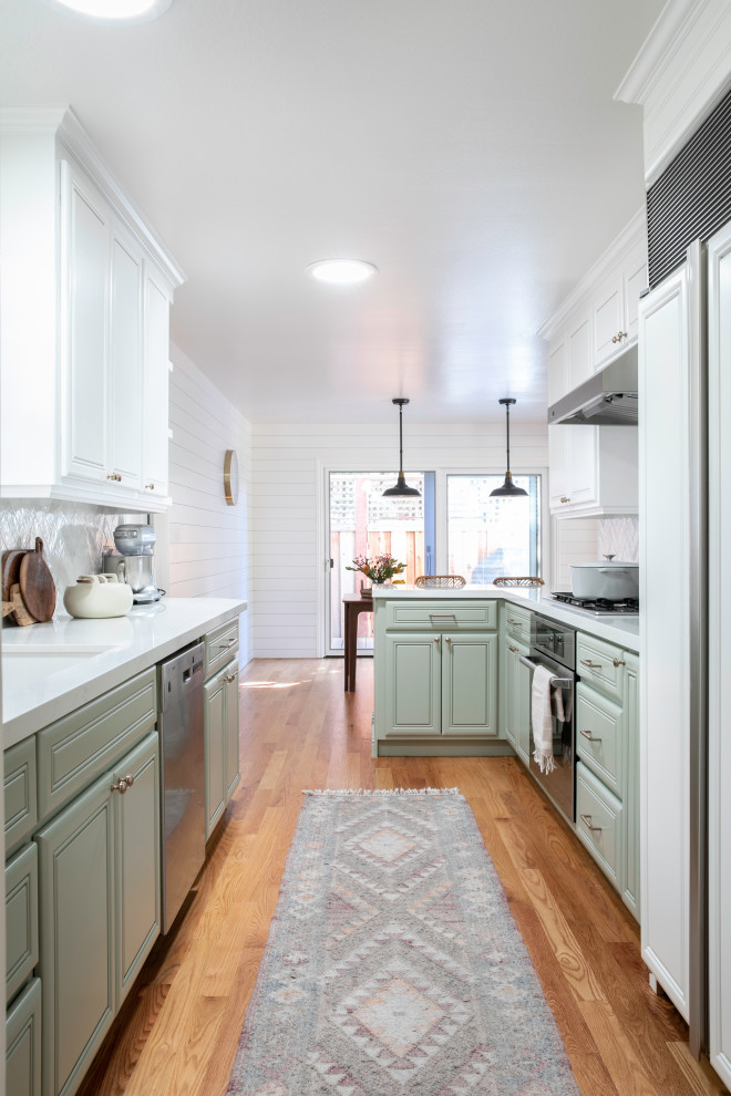 Design ideas for a small country galley separate kitchen in San Francisco with a drop-in sink, raised-panel cabinets, green cabinets, quartz benchtops, white splashback, cement tile splashback, stainless steel appliances, light hardwood floors, a peninsula and white benchtop.