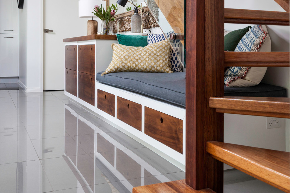 Photo of a small eclectic open concept living room in Brisbane with a library, white walls, porcelain floors, no fireplace, a built-in media wall and grey floor.