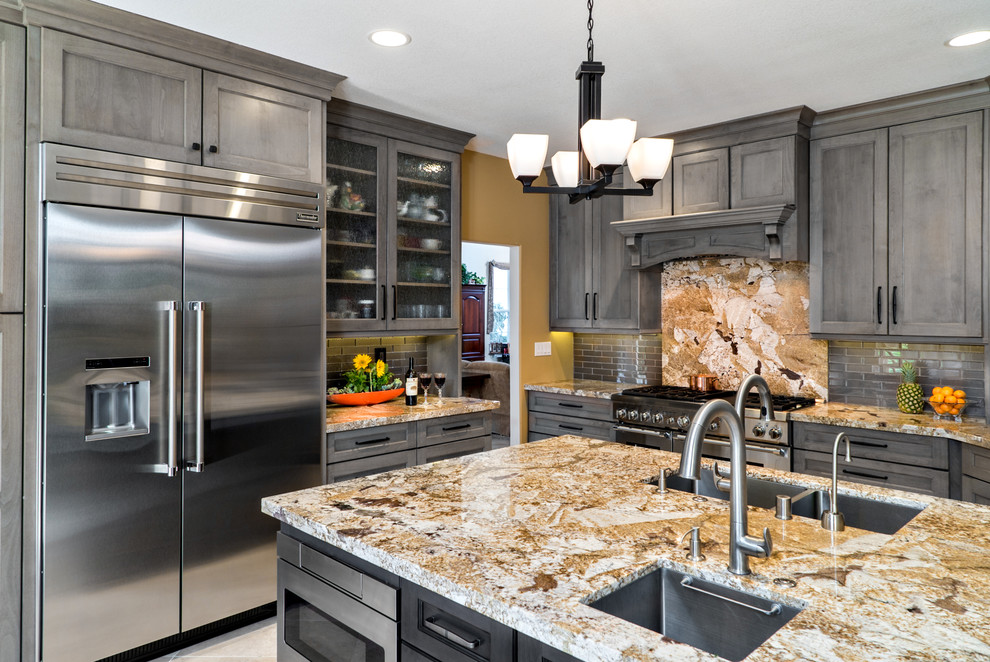 Photo of a mid-sized transitional open plan kitchen in Orange County with an undermount sink, shaker cabinets, grey cabinets, granite benchtops, grey splashback, glass tile splashback, stainless steel appliances, porcelain floors and with island.