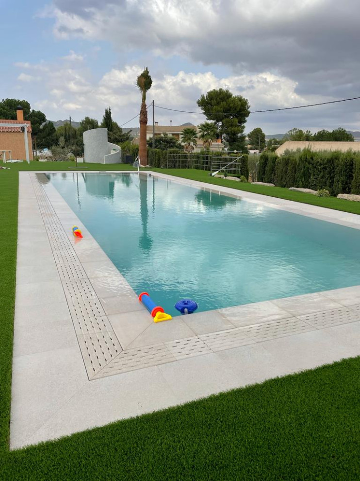 На фото: большой спортивный, прямоугольный бассейн на внутреннем дворе в стиле модернизм с домиком у бассейна и покрытием из плитки с