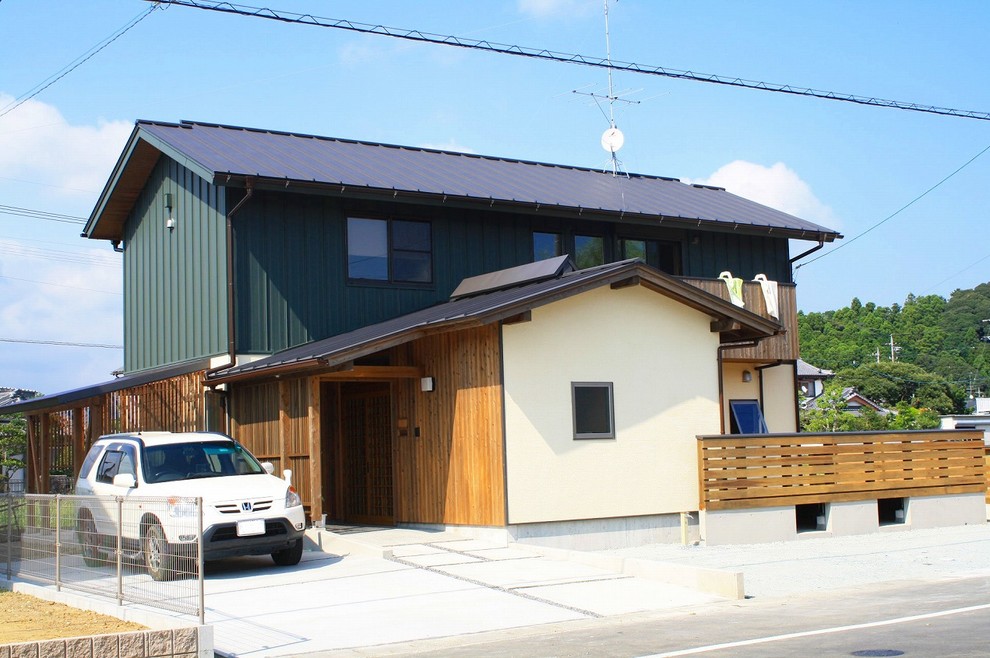 This is an example of a modern two-storey house exterior in Other with wood siding, a gable roof and a metal roof.