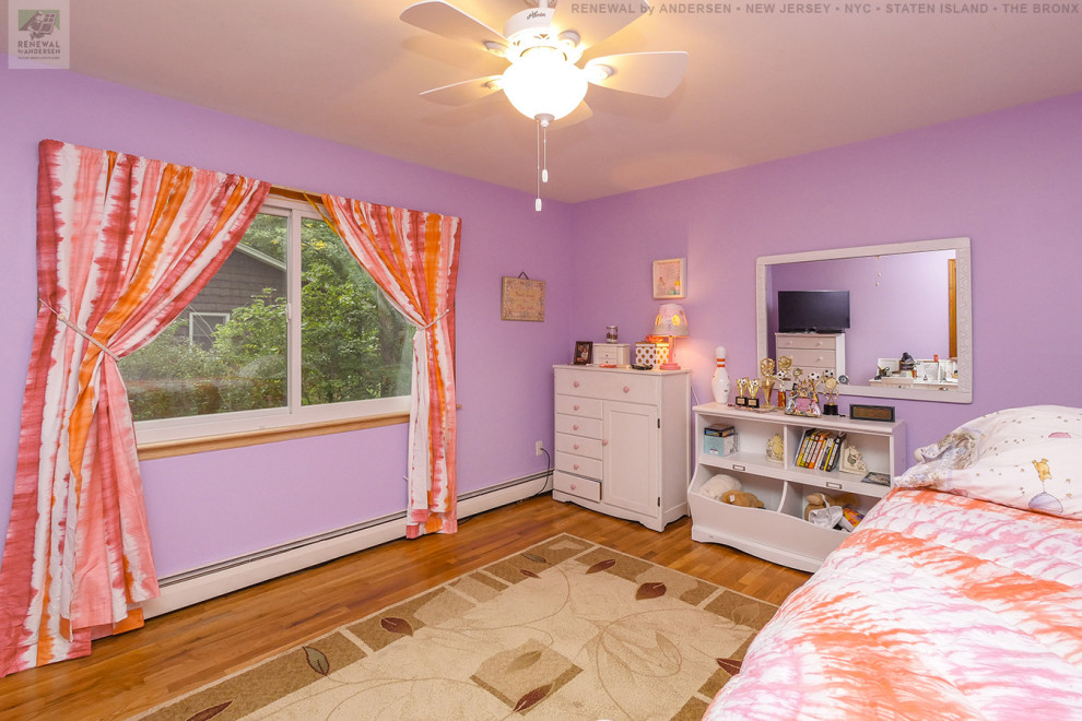 Mittelgroßes Mädchenzimmer mit Schlafplatz, rosa Wandfarbe, braunem Holzboden und orangem Boden in Newark