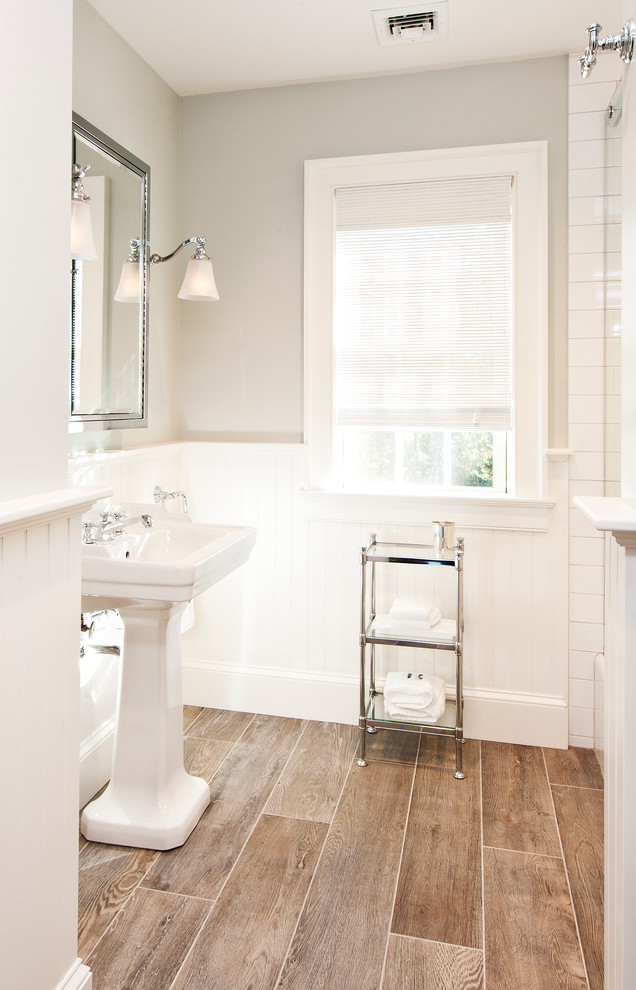 Mid-sized country bathroom in New York with white cabinets, an alcove shower, brown tile, beige walls, porcelain floors, porcelain tile and a pedestal sink.
