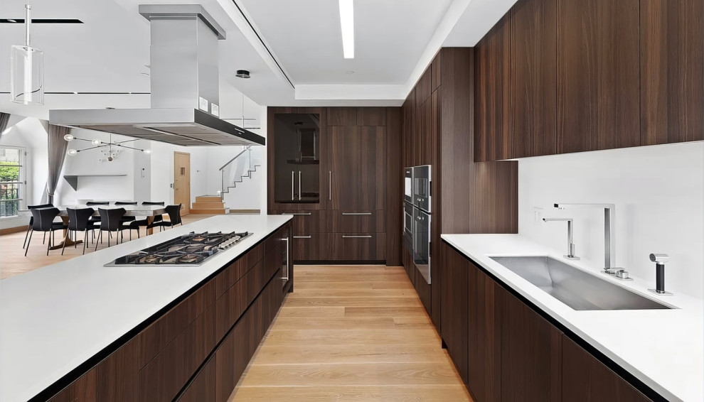 Large contemporary l-shaped open plan kitchen in New York with flat-panel cabinets, dark wood cabinets and with island.