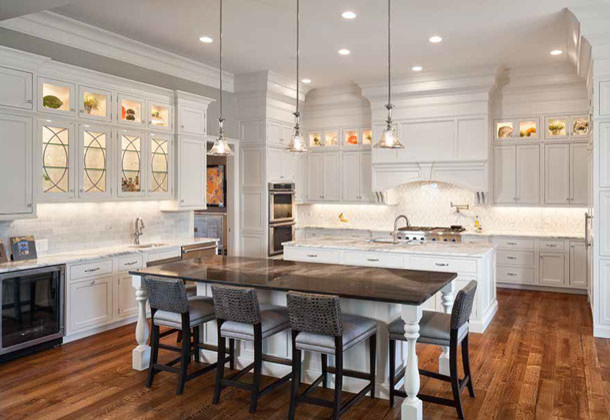 Photo of a large contemporary u-shaped eat-in kitchen in Cincinnati with an undermount sink, shaker cabinets, white cabinets, white splashback, subway tile splashback, panelled appliances, dark hardwood floors, multiple islands and brown floor.