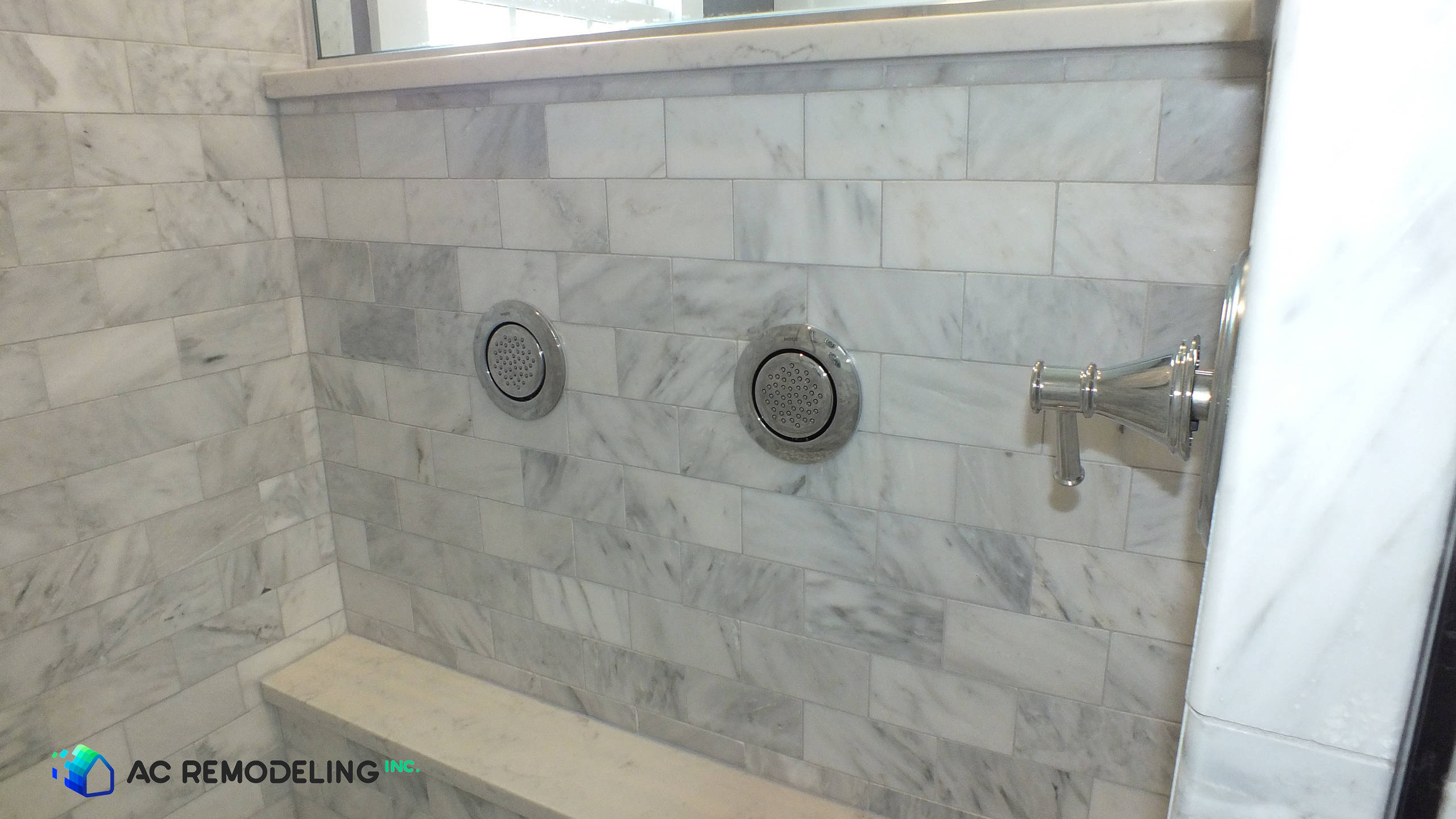 Arabescato marble shower wall and body sprays for this spa-like master bath.