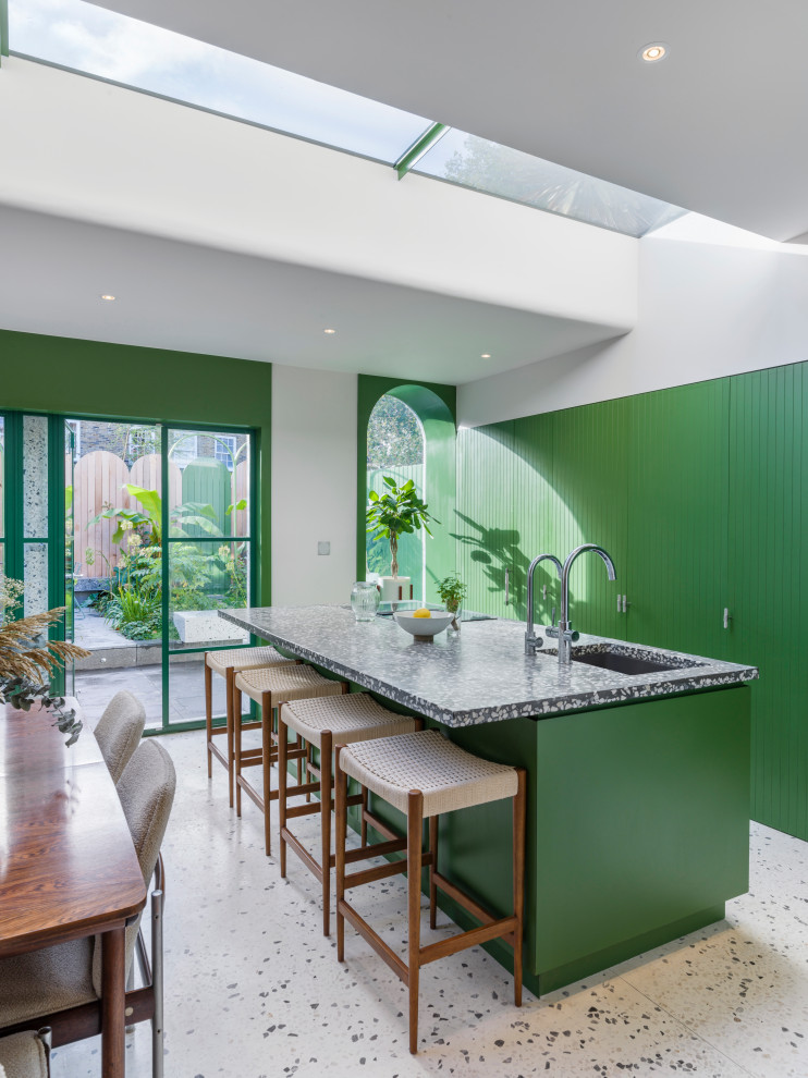 Inspiration for a contemporary galley kitchen in London with an undermount sink, flat-panel cabinets, green cabinets, with island, white floor and black benchtop.