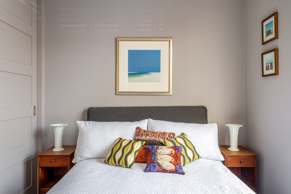На фото: гостевая спальня среднего размера, (комната для гостей) в стиле фьюжн с серыми стенами, полом из бамбука и коричневым полом
