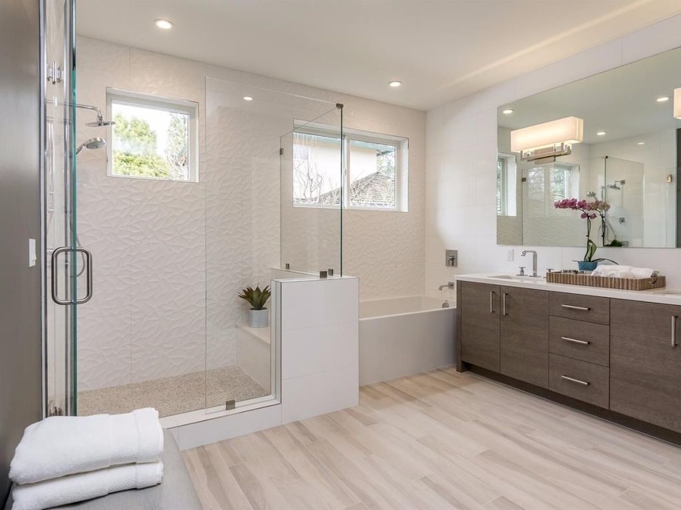 Large modern master bathroom in San Francisco with flat-panel cabinets, medium wood cabinets, an alcove tub, a corner shower, white tile, porcelain tile, white walls, light hardwood floors, an undermount sink, engineered quartz benchtops, brown floor and a hinged shower door.