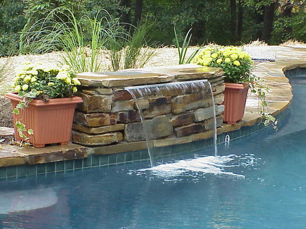Example of a mid-sized backyard stone and custom-shaped lap pool fountain design in Baltimore