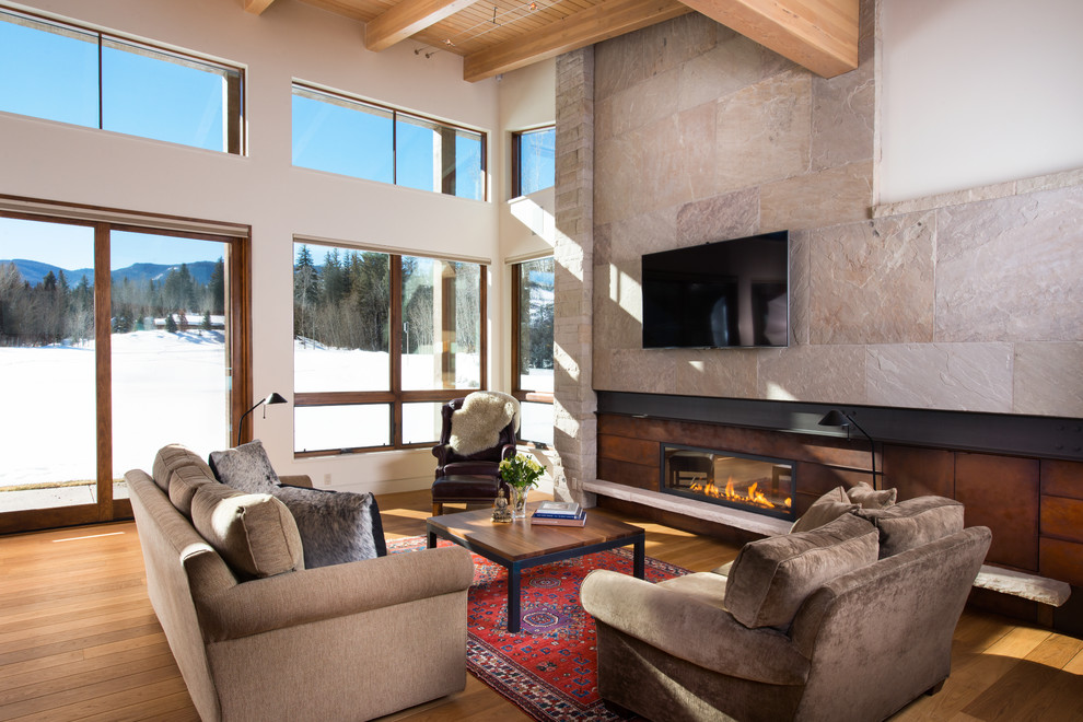 Photo of a large country living room in Denver with medium hardwood floors, a ribbon fireplace, a metal fireplace surround and a wall-mounted tv.
