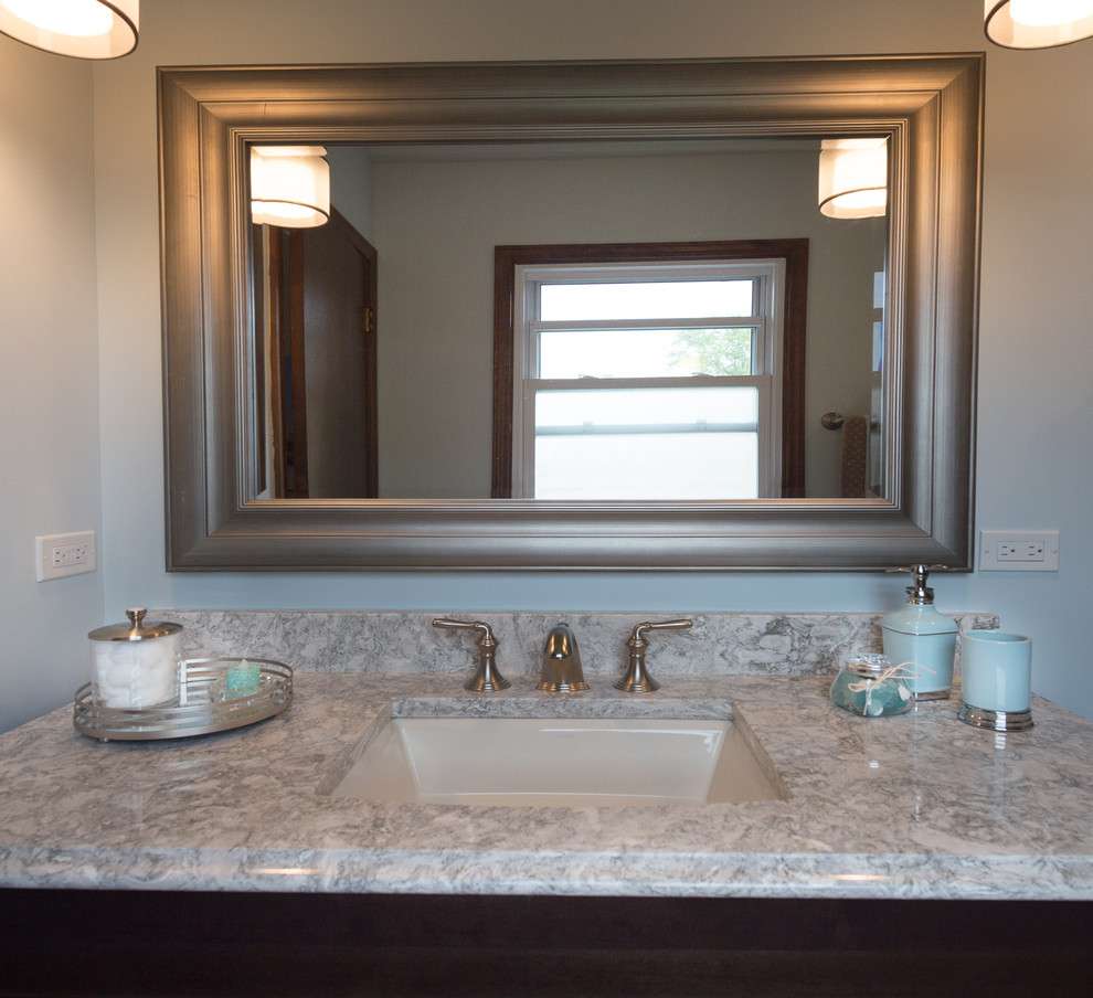 This is an example of a mid-sized transitional master bathroom in Chicago with recessed-panel cabinets, dark wood cabinets, a double shower, a two-piece toilet, beige tile, porcelain tile, blue walls, porcelain floors, an undermount sink, engineered quartz benchtops, beige floor and a sliding shower screen.