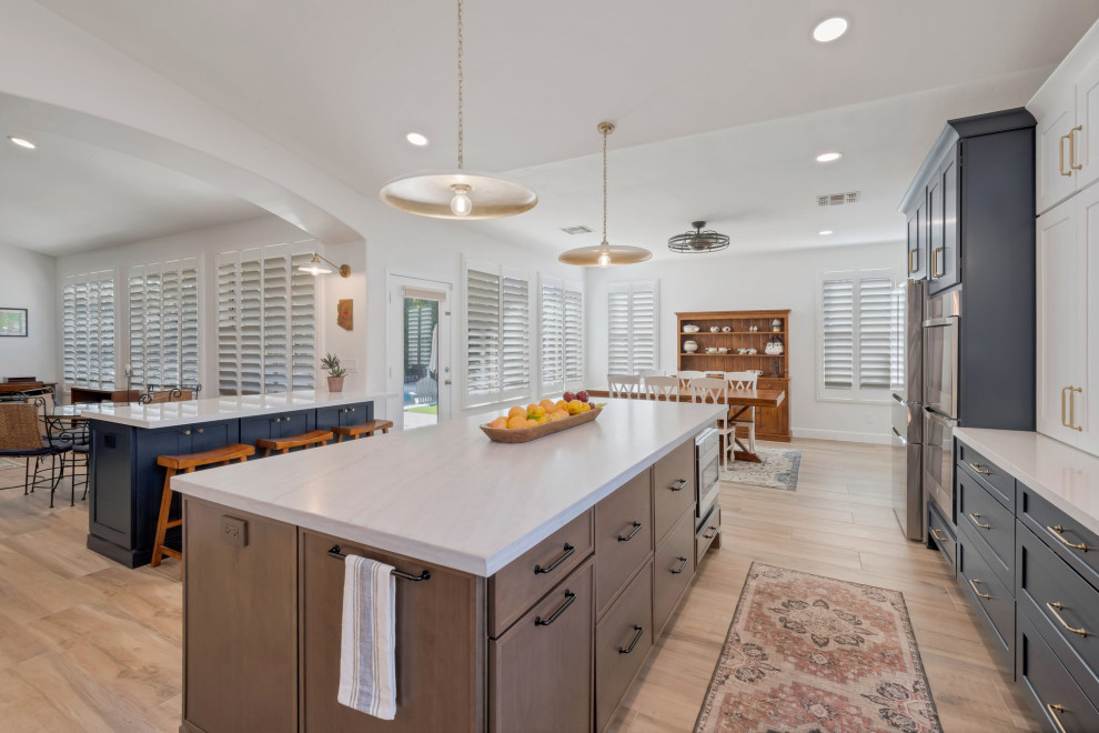 Eat-in kitchen - large transitional l-shaped porcelain tile, brown floor and vaulted ceiling eat-in kitchen idea in Phoenix with an undermount sink, shaker cabinets, blue cabinets, quartzite countertops, multicolored backsplash, mosaic tile backsplash, stainless steel appliances, two islands and white countertops