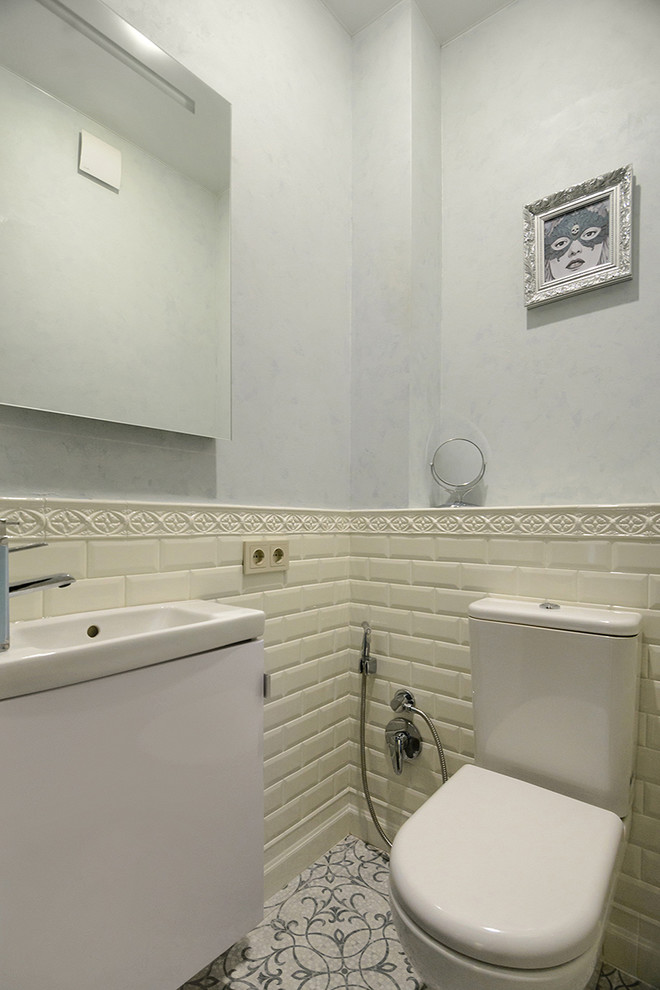 This is an example of a small transitional powder room in Novosibirsk with a wall-mount toilet, beige tile, ceramic tile, beige walls and a wall-mount sink.