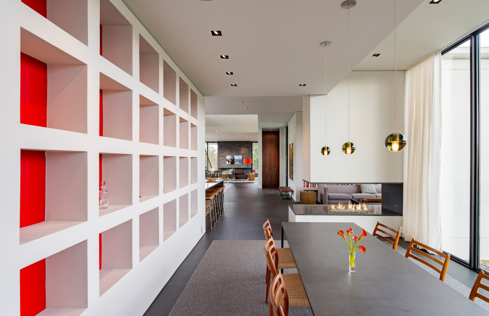 Идея дизайна: огромная гостиная-столовая в современном стиле с белыми стенами, полом из керамогранита, двусторонним камином, серым полом и многоуровневым потолком