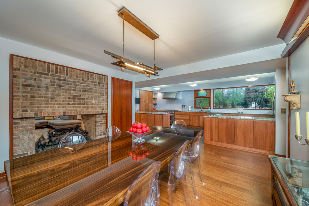 This is an example of a mid-sized midcentury kitchen/dining combo in Other with blue walls, a two-sided fireplace, a brick fireplace surround and cork floors.