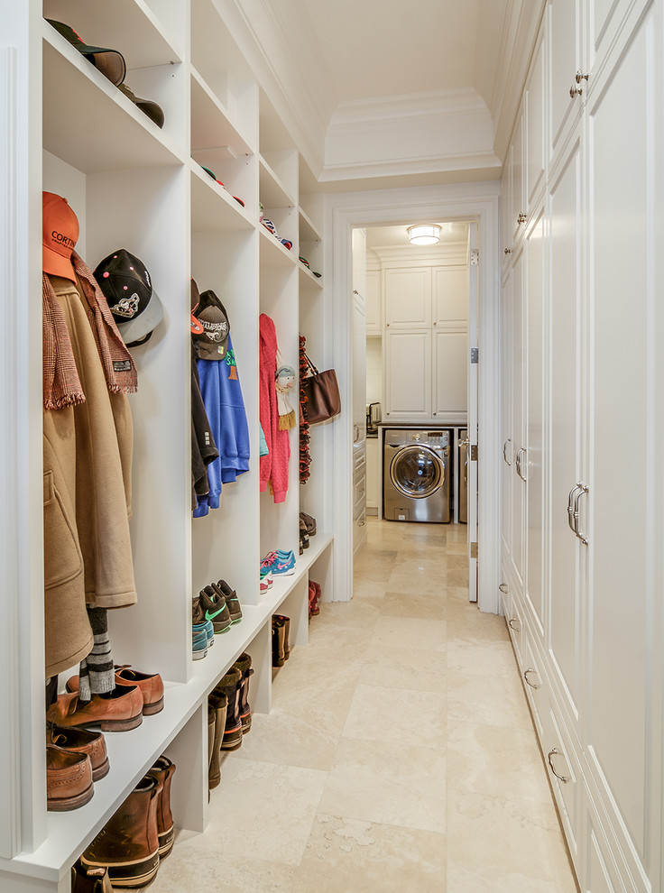 This is an example of a traditional mudroom in Calgary with travertine floors, white walls and beige floor.