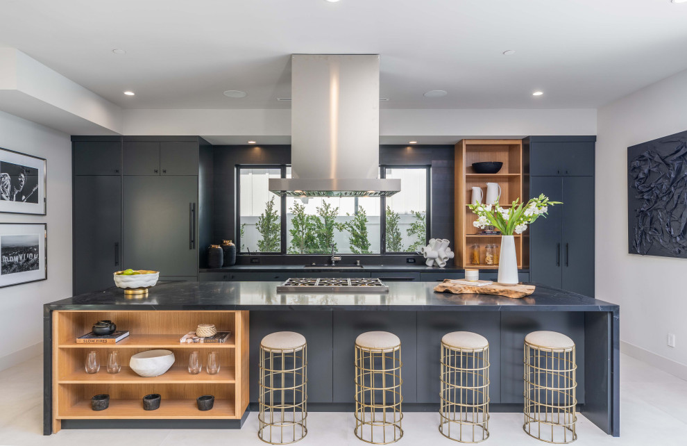 This is an example of a large contemporary single-wall open plan kitchen in Los Angeles with a submerged sink, flat-panel cabinets, black cabinets, engineered stone countertops, integrated appliances, porcelain flooring, an island, grey floors, black worktops and a drop ceiling.